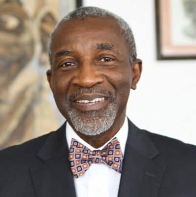 Senior Nigerian businessman Foluso Phillips in a formal suit and bow tie.