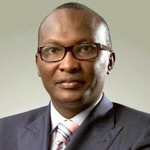 About Us 12 African business leader Michael Macharia in formal attire with glasses.