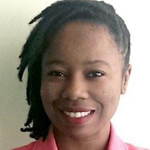 African woman with dreadlocks smiling warmly.
