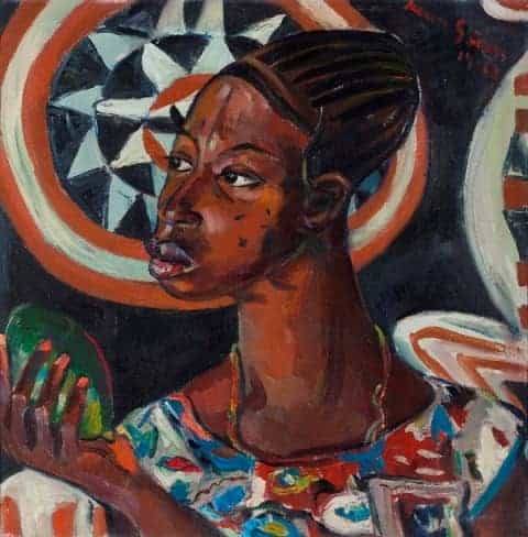 African woman holding a green fruit in traditional attire.