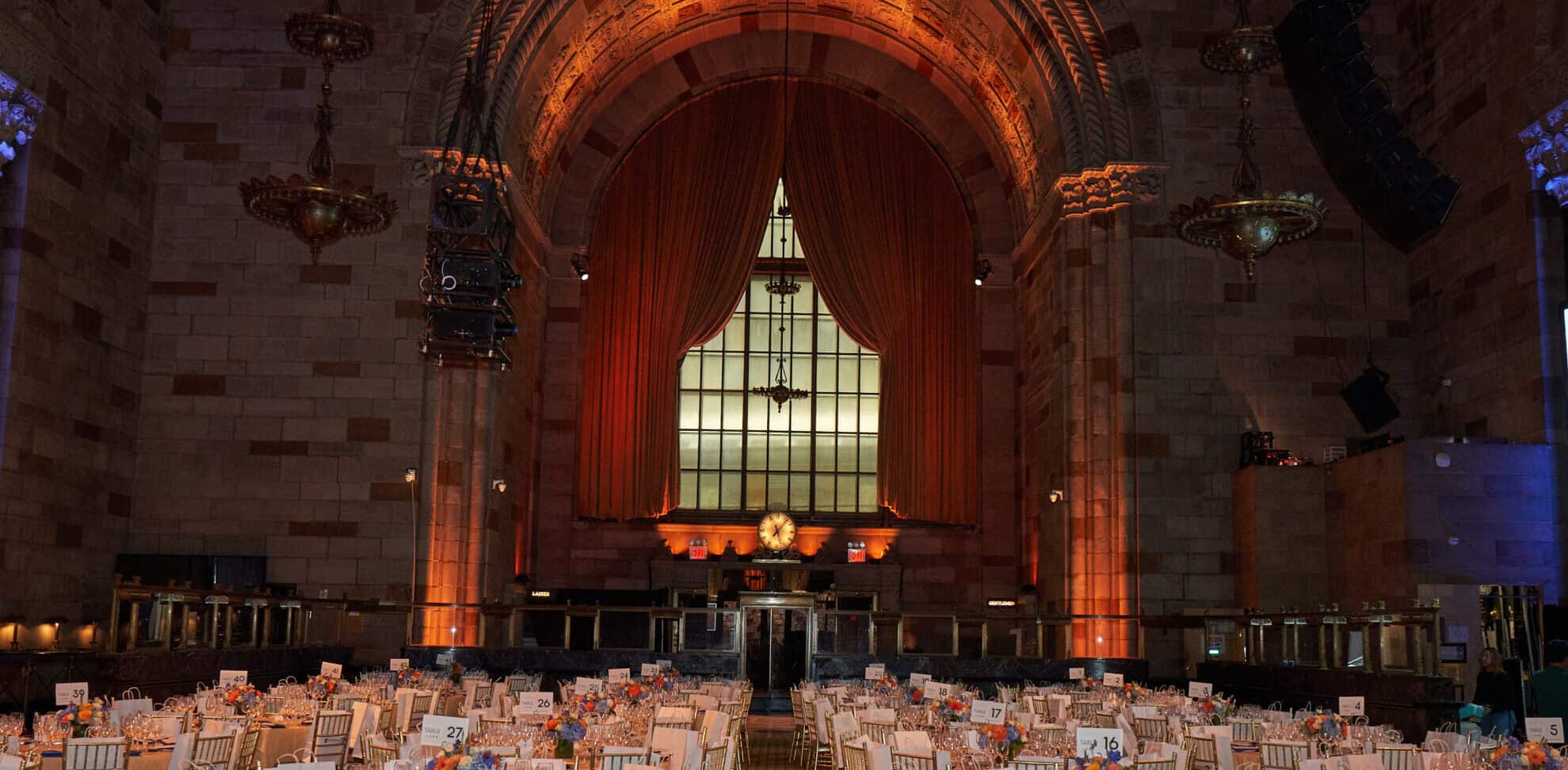 Interior view of a grand conference hall with high ceilings, elegant drapes, and seating arrangement.