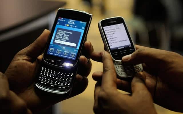 Mobile phones showing text messages during a Nigerian business awards ceremony.