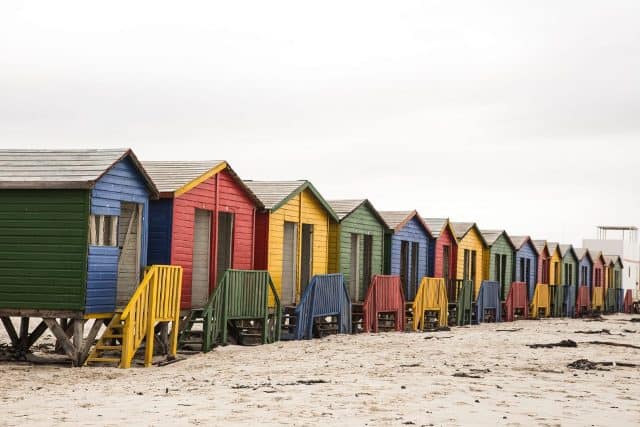 Colorful beach huts on the African coast with vibrant hues and seaside setting.