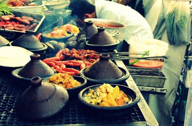 Traditional African street food served in clay pots with vibrant ingredients.