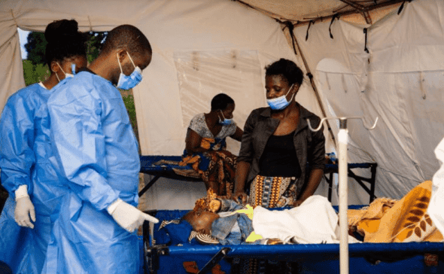 Medical team providing emergency healthcare in an outdoor tent in Africa.