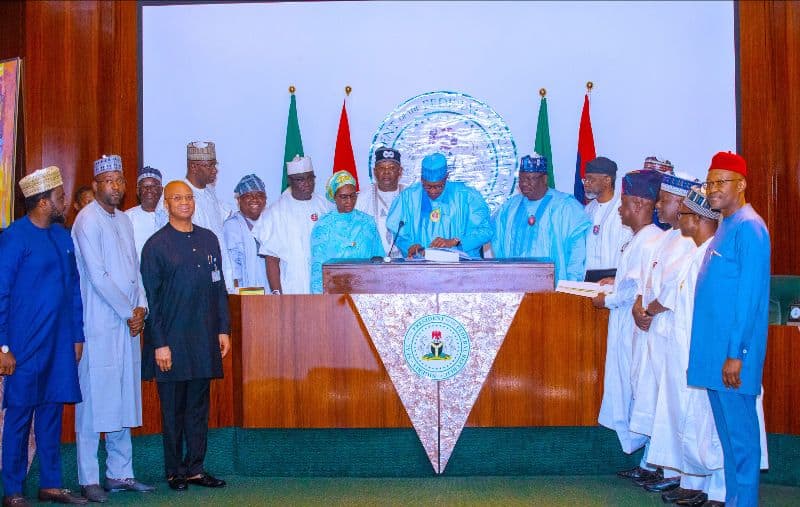African leaders signing official documents at a formal government meeting.
