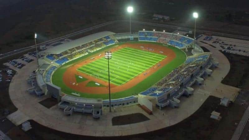 Football stadium at night with bright floodlights and empty stands.