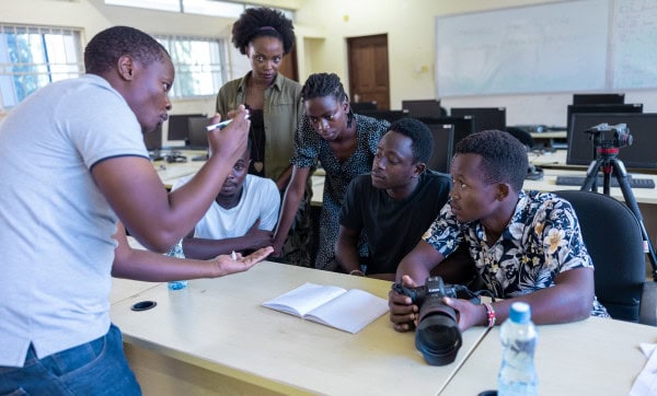 Kenyan youth engaged in digital media training session in a classroom setting.