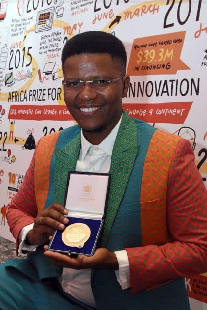 African artist receiving award at a cultural event.