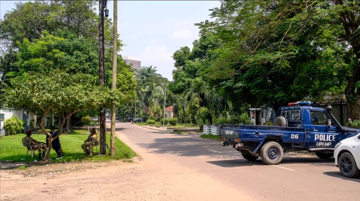 Urban scene featuring a police truck and lush greenery, highlighting safety and growth in African st.