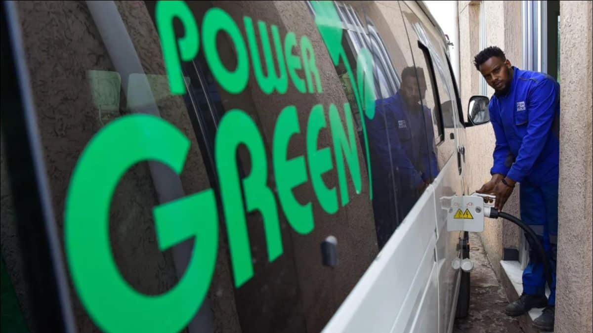 Young man using eco-friendly equipment outside a van with Power Green logo.