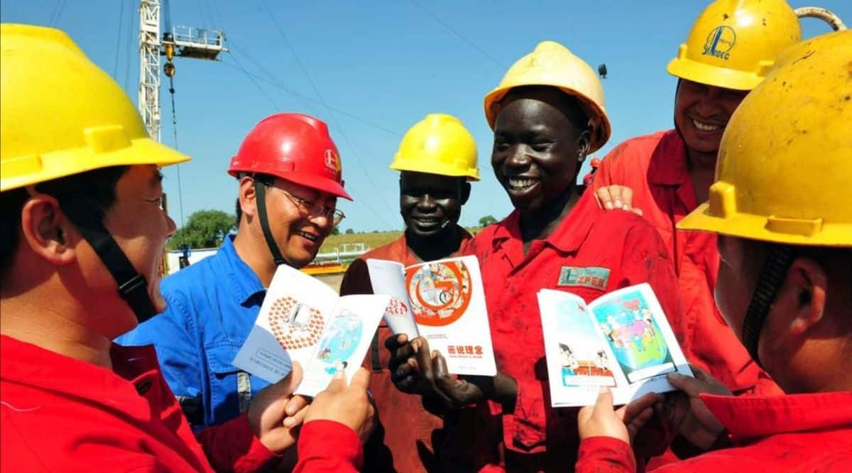 South African business professionals in safety gear discussing plans outdoors.