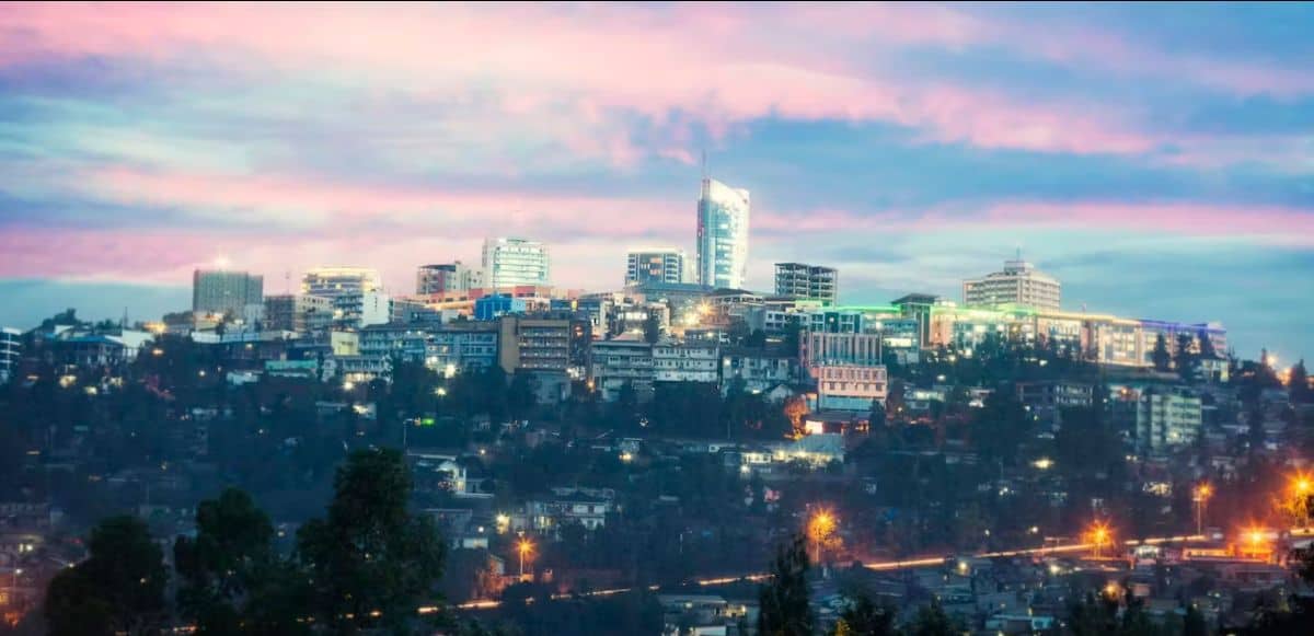 Urban skyline of Windhoek, Namibia during sunset with city lights and modern buildings.