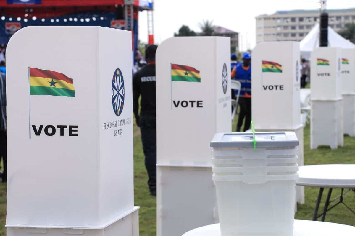 Ballot boxes at Ghana election site with Ghana flag and voting process.
