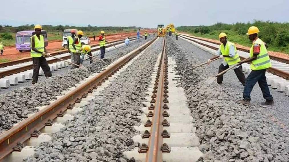 Workers installing railway tracks in Egypt to improve transportation infrastructure.
