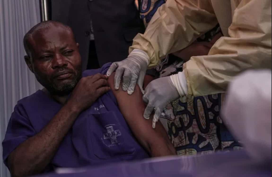 Healthcare worker administering COVID-19 vaccine to a man in Côte d'Ivoire.