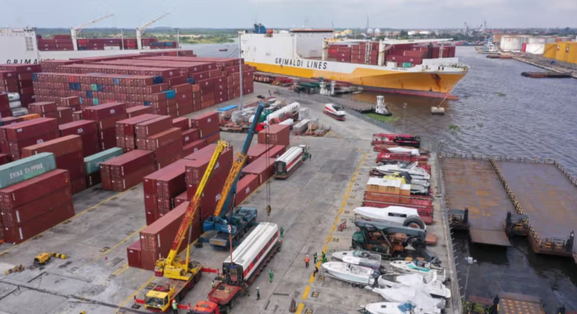 Container port with cargo ships, cranes, and trucks at Uganda's harbor.