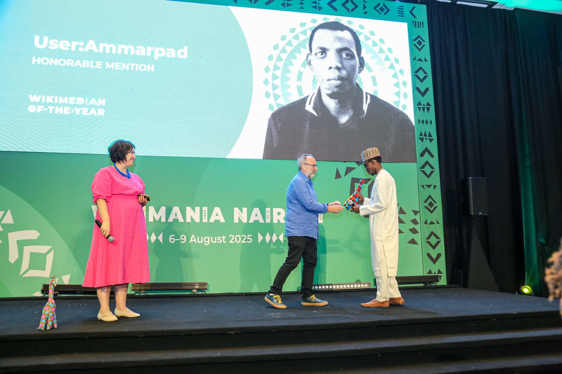 Jimmy Wales awards a volunteer at Wikimania 2025 in Kenya during the event.