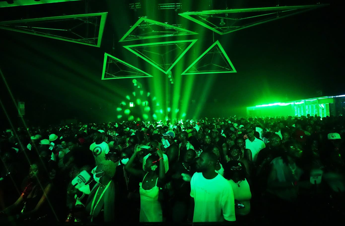 Underground Lagos nightclub with neon green lighting and energetic crowd.