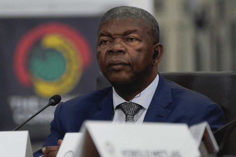 Angolan president signing a repressive civil society law at a formal event.