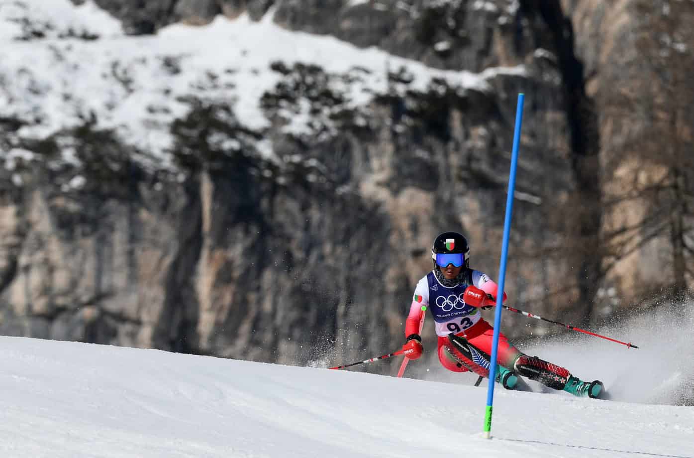 African skier competing in a winter sports event on snow-covered slopes.