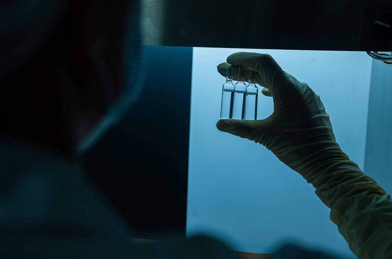 Scientist holding test tubes in a laboratory for vaccine development in Africa.