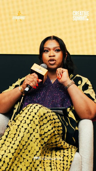 Diverse African woman speaking at a cultural summit, emphasizing creativity and collaboration in Afr.