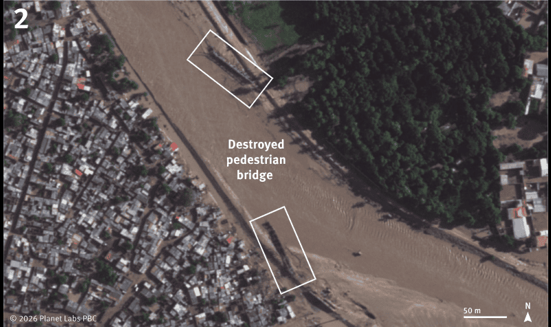 Flood survivors crossing damaged pedestrian bridge over a river in Angola.
