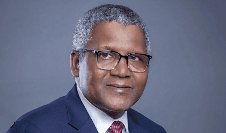 Portrait of a professional man in a suit and glasses, representing Dangote's expansion plans.